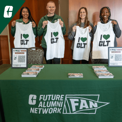 Future Alumni Network Photo of group standing, holding up I Heart Charlotte tank tops